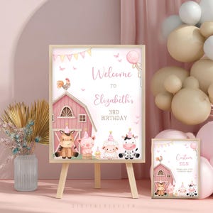 Puede incluir: Un letrero de cumpleaños con temática de granja en rosa y blanco con el texto "Welcome to Elizabeth's 3rd Birthday". El letrero presenta ilustraciones de animales de granja y un granero. También hay un letrero más pequeño a juego.