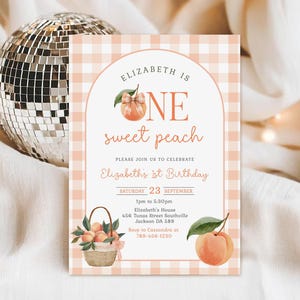 Puede incluir: Invitación de cumpleaños con temática de melocotón con el texto "Elizabeth is One Sweet Peach". La invitación presenta una ilustración de melocotón y hoja, una cesta de melocotones y un fondo de cuadros. La invitación incluye la fecha, la hora y el lugar.