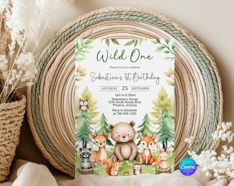 May include: A rectangular birthday invitation card featuring watercolor illustrations of a bear, deer, fox, raccoon, squirrel, and hedgehog in a forest. The text reads Wild One, Sebastian's 1st Birthday, Saturday 25 September, and event details.