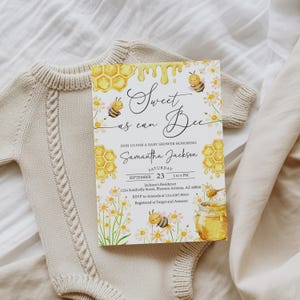 May include: A rectangular baby shower invitation card featuring watercolor illustrations of yellow honeycombs, dripping honey, daisies, and bees. The text reads Sweet as can Bee, Join us for a baby shower honoring Samantha Jackson, Saturday September 23.