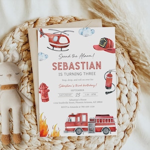 May include: A rectangular birthday invitation card featuring watercolor illustrations of a red fire truck, a fire hydrant, a fire extinguisher, a helmet, and a helicopter. The text reads: Sound the Alarm! SEBASTIAN IS TURNING THREE. September 23.