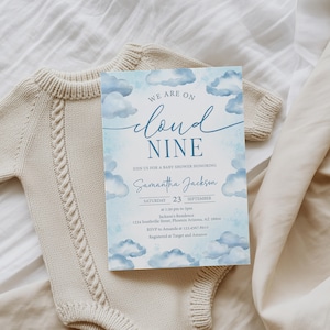 May include: A baby shower invitation with a blue watercolor cloud design and the text "We are on cloud nine." The invitation includes the name "Samantha Jackson" and event details. A beige knitted baby onesie is in the background.