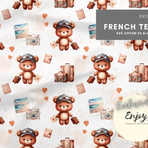 May include: A seamless pattern featuring brown teddy bears wearing aviator goggles and carrying suitcases. The background is white with pink hearts, passport illustrations, and vintage cameras. The text "EXTENSIBLE FRENCH TERRY 95% COTON 5% ELASTHANNE" is at the top of the pattern. The text "Exclusive Enjoy Tissus & Mercerie" is at the bottom of the pattern.