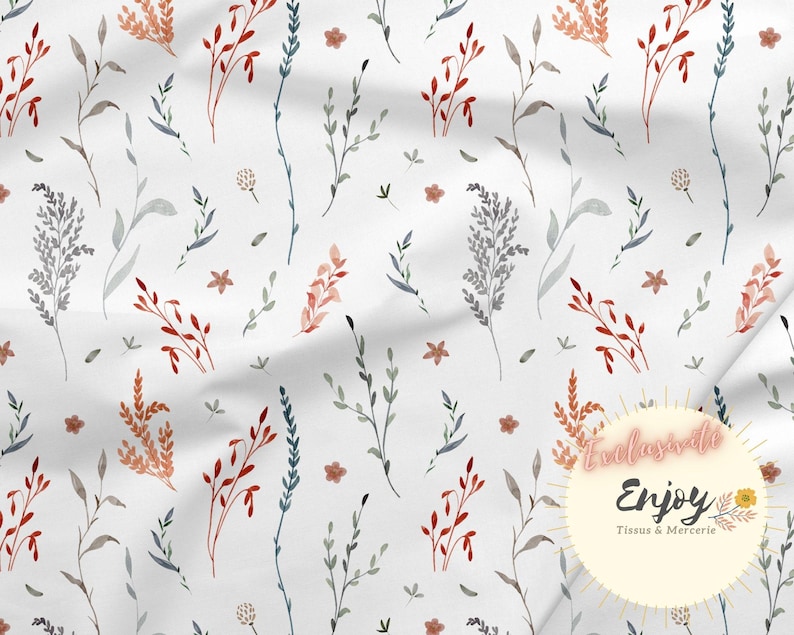 May include: A white fabric with a repeating pattern of watercolour-style floral sprigs in shades of blue, grey, and orange. The fabric has a subtle texture and a soft, flowing drape.