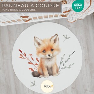 May include: A white round play mat featuring a cute fox illustration. The fox is sitting on a bed of red and green leaves. The text "Enjoy" is printed on the mat.
