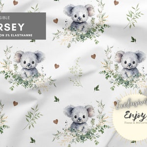 K&ouml;nnte beinhalten: Wei&szlig;er Stoff mit einem sich wiederholenden Muster aus grauen Koalas, die in gr&uuml;nen Eukalyptusbl&auml;ttern sitzen. Der Stoff hat ein braunes Herzmuster und den Text "EXTENSIBLE JERSEY 95%COTON 5%ELASTHANNE" oben.