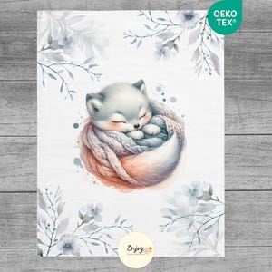 May include: A watercolor illustration of a white fox curled up asleep in a cozy, gray and pink knitted blanket. The fox is surrounded by delicate, light blue watercolor flowers and leaves. The image has the text "Oeko Tex&reg;" in the top right corner and "Enjoy" in the bottom center.