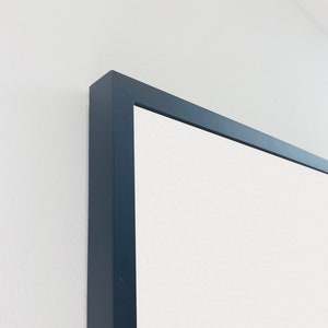 May include: Close-up of the top corner of a black picture frame.