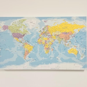 May include: A vibrant world map print, featuring countries in diverse colours such as yellow, green, and purple. The oceans are depicted in a light blue hue. Continents are labelled, and the map is mounted on a rectangular canvas, suitable for display.
