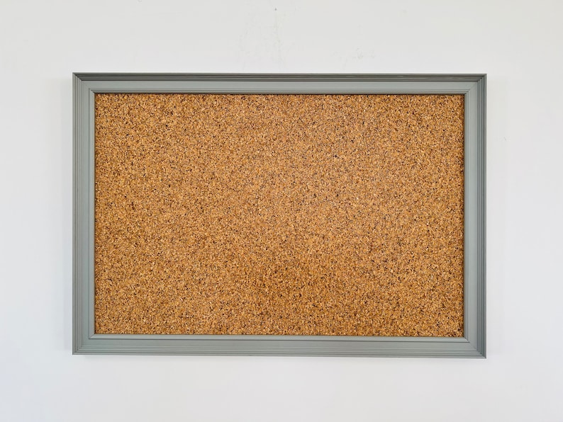 May include: A gray framed corkboard with a brown cork surface.