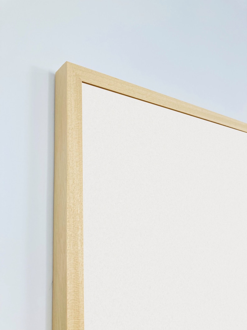 May include: Close-up of the top corner of a light wood frame with a white canvas insert.