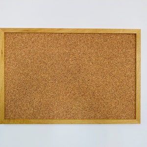 May include: A brown corkboard with a wooden frame.