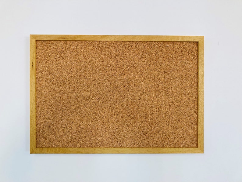May include: A brown corkboard with a wooden frame.