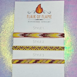 Könnte beinhalten: Drei Perlenarmbänder in verschiedenen Stilen, jedes mit einem Farbschema aus Rot, Gelb und Weiß. Die Armbänder sind mit "Style 1", "Style 2" und "Style 3" gekennzeichnet.