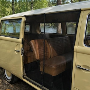 May include: A light yellow camper van with a sliding side door open, revealing a brown vinyl interior with bench seating. A black mesh screen is installed across the door opening. The exterior features a white roof and chrome door handles.