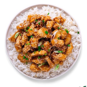 May include: A plate of white rice topped with sesame chicken, garnished with green onions and sesame seeds.