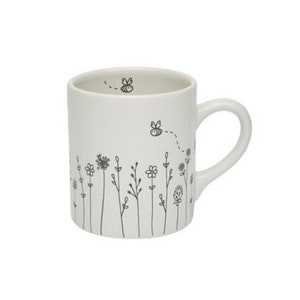 May include: White ceramic mug with a black line drawing of a field of flowers and bees. The mug has a handle.