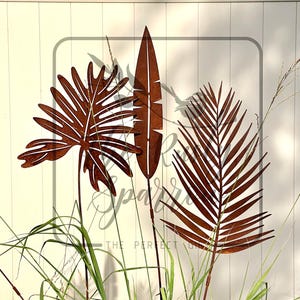 Zardzewiałe metalowe paliki do liści palmowych: wystrój ogrodu tropikalnego