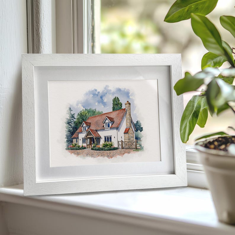 K&ouml;nnte beinhalten: Ein Aquarellbild eines wei&szlig;en Hauses mit rotem Dach und brauner T&uuml;r. Das Haus ist von gr&uuml;nen B&auml;umen und B&uuml;schen umgeben. Das Bild ist in einem wei&szlig;en Rahmen gerahmt.