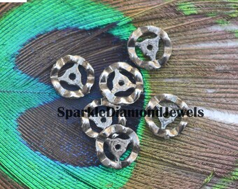May include: Six silver-toned metal round beads with a three-pointed star design. The beads are on a peacock feather background.