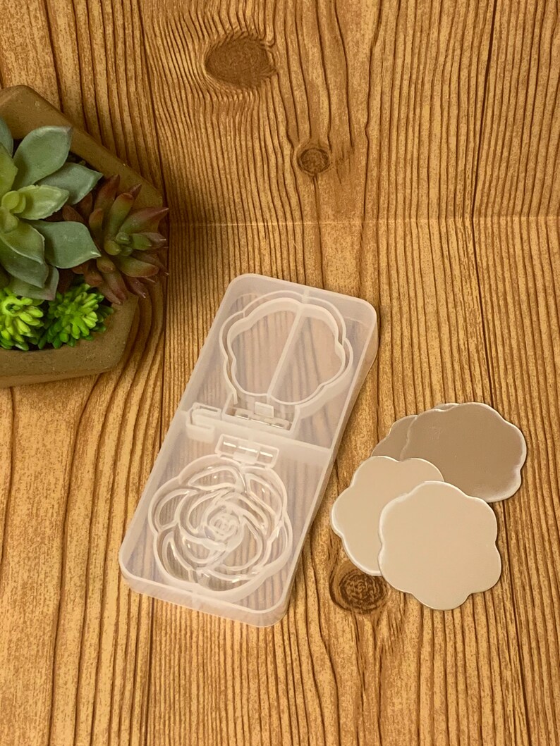 May include: A clear plastic mold for making resin crafts. The mold has two sections, one with a rose design and the other with a flower design. Three small, round, flower-shaped mirrors are also included.