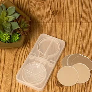 May include: A clear silicone mold for making resin ornaments. The mold is shaped like a round ornament with a star design. There are also four clear round resin blanks included.
