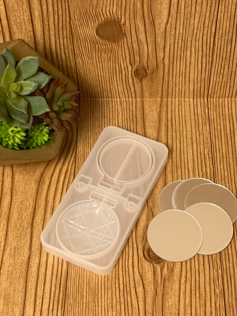 May include: A clear silicone mold for making resin ornaments. The mold is shaped like a round ornament with a star design. There are also four clear round resin blanks included.