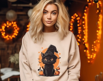 Puede incluir: Sudadera beige con un gato negro de dibujos animados con un sombrero de bruja, sobre un círculo naranja con calabazas y murciélagos. Ideal para Halloween. La sudadera es de color neutro.