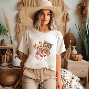 a woman sitting on a bed wearing a t - shirt with two dogs on it