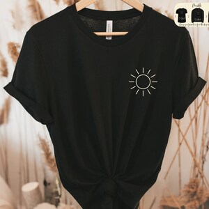 May include: Black t-shirt with a white sun graphic on the front. The shirt is made of a soft, comfortable material.