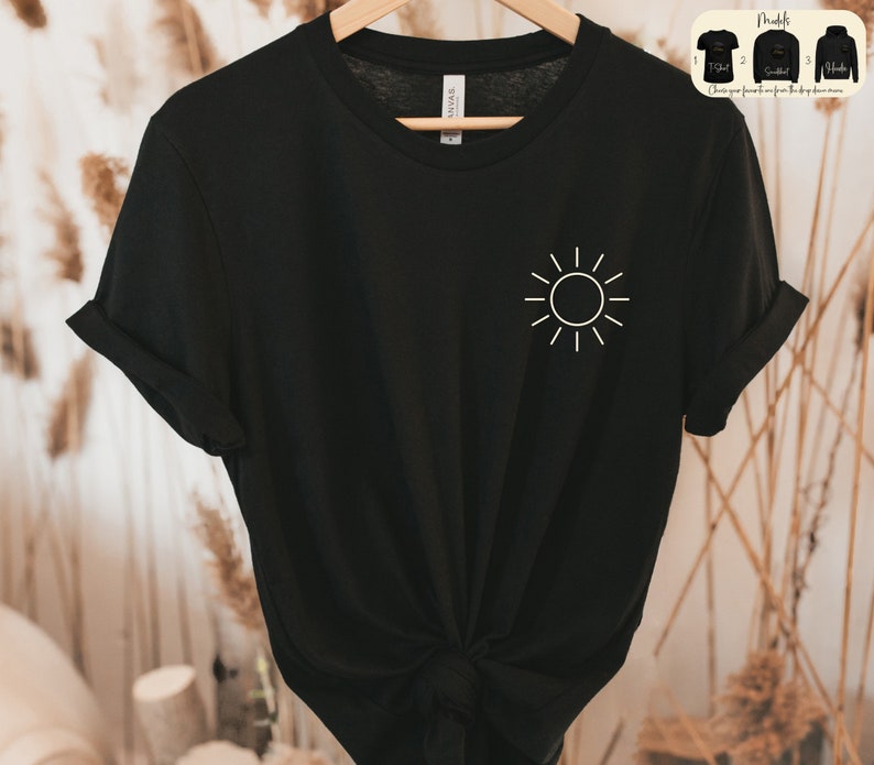 May include: Black t-shirt with a white sun graphic on the front. The shirt is made of a soft, comfortable material.