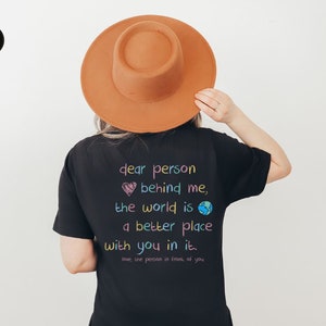 May include: Black t-shirt with a colorful graphic that reads "dear person behind me, the world is a better place with you in it. love the person in front of you".