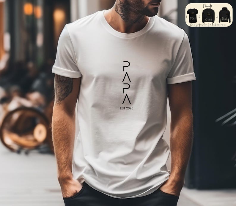 May include: White t-shirt with black text that reads "PAPA EST 2025" with the letters arranged vertically in a geometric pattern.