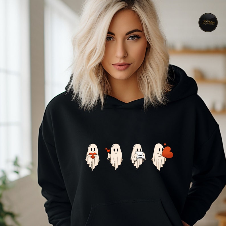 May include: Black hooded sweatshirt with a graphic of four ghosts wearing hearts and holding signs that say "I love you" and "Boo".