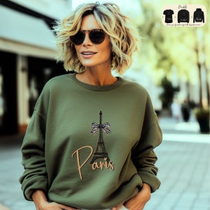 a woman wearing a sweatshirt with the eiffel tower on it