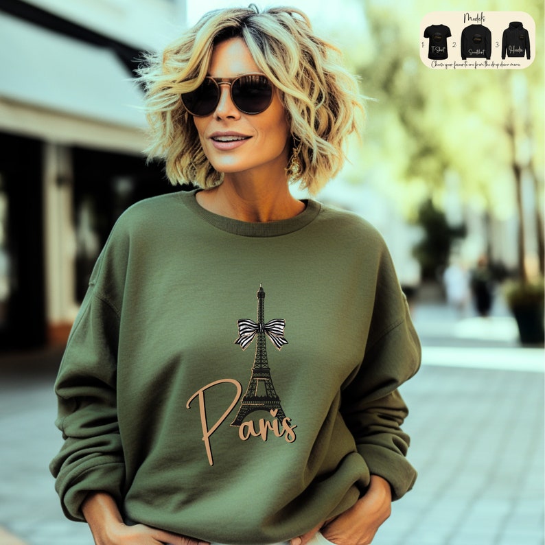 a woman wearing a sweatshirt with the eiffel tower on it