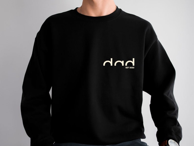 May include: Black sweatshirt with a white graphic that says "dad est 2023".