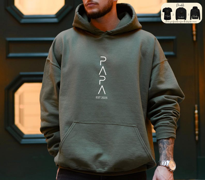 May include: A green hooded sweatshirt with the word "PAPA" written vertically in white, with the letters forming triangles. The text "EST 2025" is written below the word "PAPA".