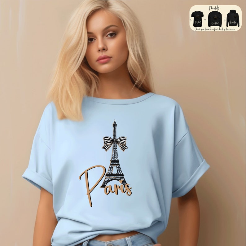 a woman wearing a blue shirt with the eiffel tower on it