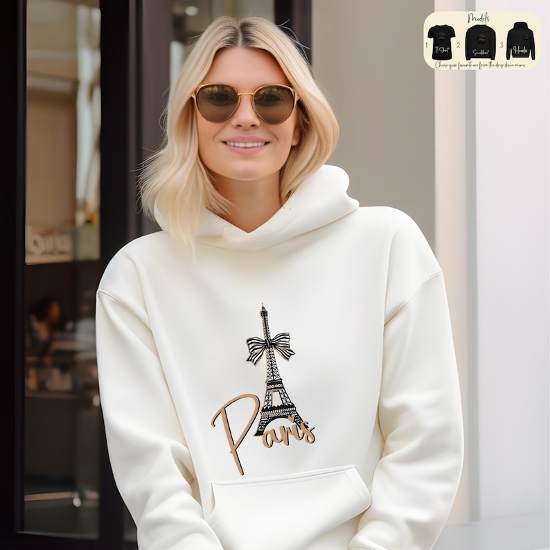 a woman wearing a white hoodie with a picture of the eiffel tower