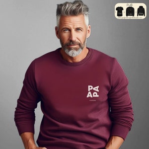 Op de afbeelding: Een bordeauxrood sweatshirt met een witte afbeelding die "PAPA" en "Andreas" eronder zegt.