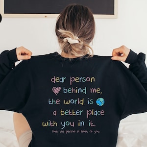 May include: Black sweatshirt with a rainbow colored message that reads "dear person behind me, the world is a better place with you in it. love, the person in front of you"