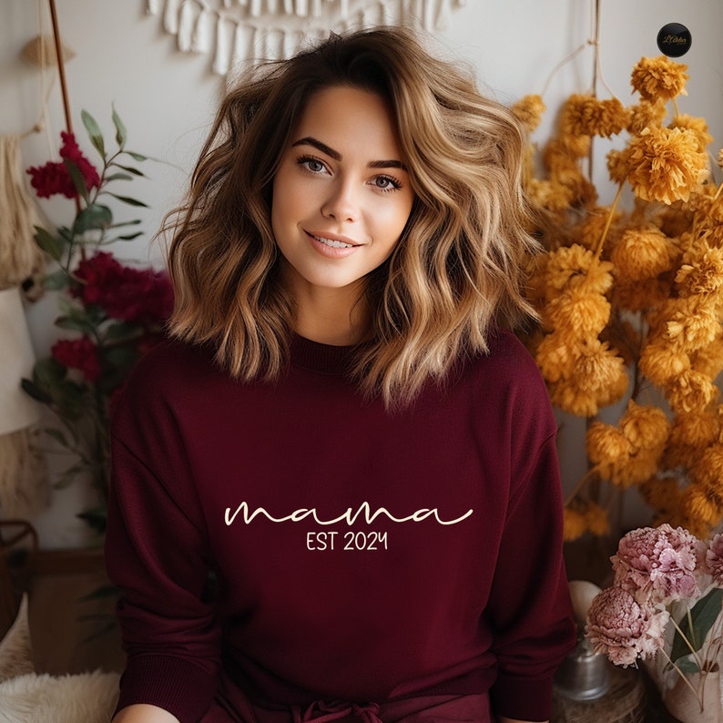 a woman wearing a maroon sweatshirt with a name on it