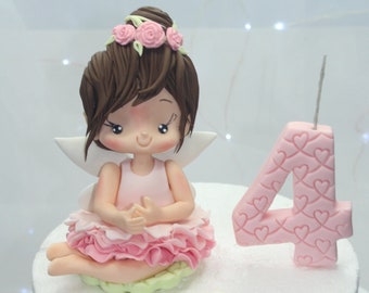 Cute fairy figure cake topper in dress and pink flowers in fondant or cold porcelain for children's fairy parties, gardens and baby shower.