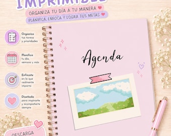 May include: A light pink spiral-bound planner with the word Agenda printed in black script. The cover features a rectangular illustration of a blue sky with clouds over a green landscape. A light pink pen rests beside the planner on the right side.