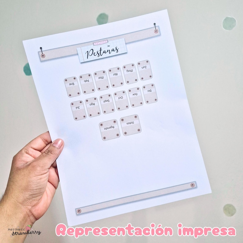 May include: A white printed sheet featuring a horizontal banner at the top with the text Pesta&ntilde;as, followed by twelve small rectangular labels with rounded corners, each containing a month name in Spanish, plus two additional labels for Agenda and Notas.