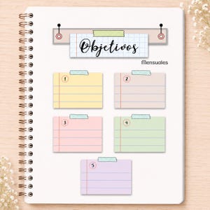 May include: A spiral-bound notebook page featuring a header with the text "Objetivos" and "Mensuales" above five rectangular, lined sticky note graphics in yellow, beige, pink, light green, and light purple, each numbered one through five.
