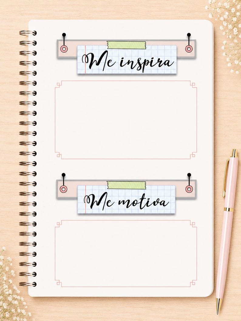 May include: A spiral-bound notebook page featuring two rectangular sections with pink borders. Above each section is a grid-paper label attached with pins and tape, reading Me inspira and Me motiva in black script, accompanied by a light pink pen.