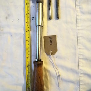 May include: A vintage screwdriver set with a wooden handle, metal shaft, and interchangeable bits. The main screwdriver is approximately 30 cm long. Includes a measuring tape and a tag with the number 002668.