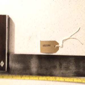 May include: A vintage metal try square with a wooden handle. The handle has three decorative diamond-shaped inlays. The try square has a tag attached with the number 922190.